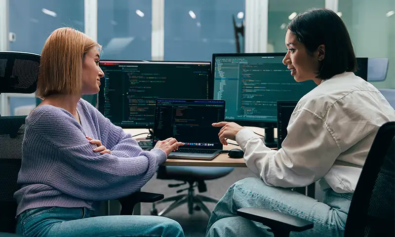 Two IT professionals interacting with their organization's high-performing artificial intelligence
