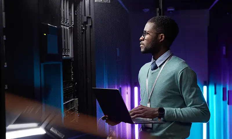 IT professional with laptop looking at their hyperconverged infrastructure solution.