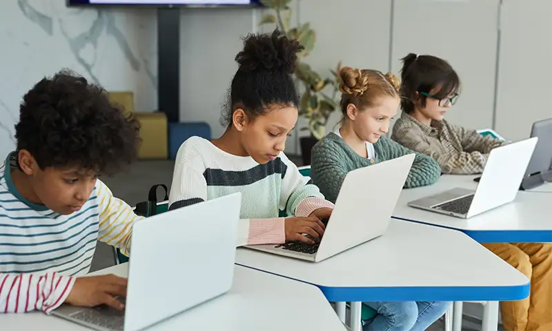 school children working on district provided devices